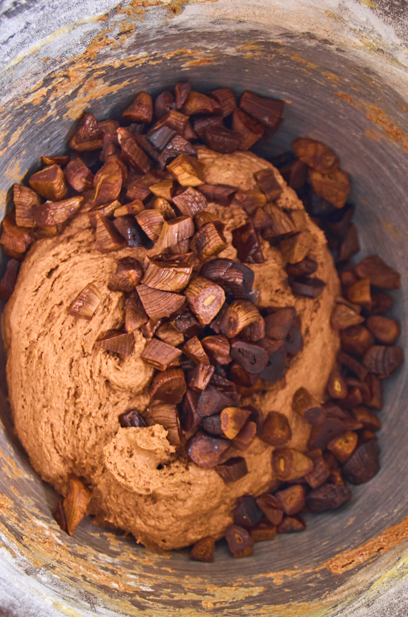 The dough is mixed in s standmixer bowl, the chopped blck garlic added on top, ready to mix in.